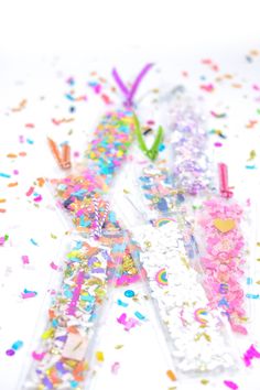 three plastic toothbrushes with confetti and sprinkles on them