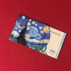 an euro bill with the starry night painting on it is laying on a red surface