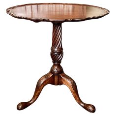 a wooden table with an intricate design on it's legs and a circular top