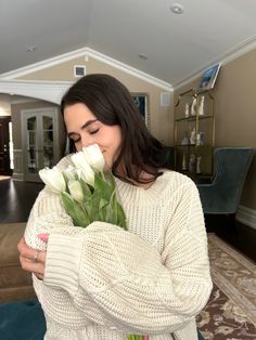 a woman is holding flowers in her hands