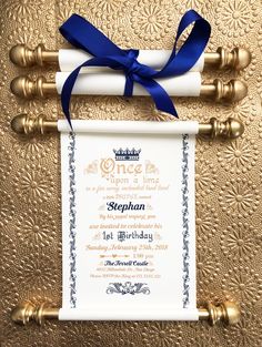 a scroll with a blue ribbon tied around it on top of a gold table cloth