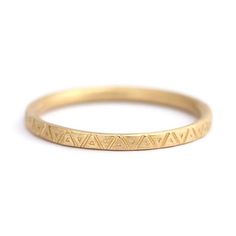 a yellow gold band with small triangles on it