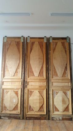 three wooden doors in an empty room