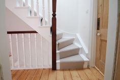 a staircase leading up to the second floor in a house with white walls and wood floors