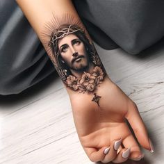 a woman's hand with a tattoo of jesus on it and flowers around the wrist