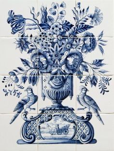 a blue and white tile wall with flowers in a vase on the bottom, two birds sitting on top