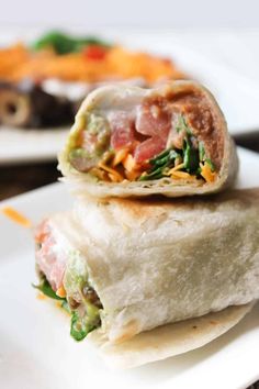 two burritos stacked on top of each other with meat and veggies