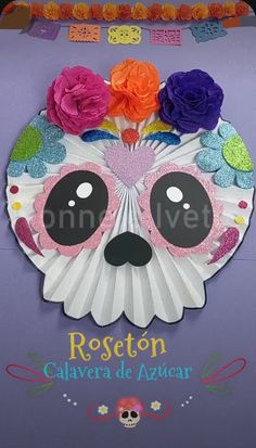 a paper plate with a skull and flowers on it's head, in the shape of a fan