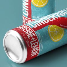 two cans of energy drink on a blue surface with a red ribbon around the can