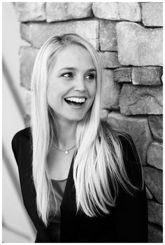 a black and white photo of a woman with long blonde hair smiling at the camera