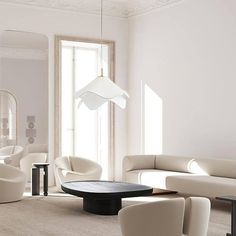 a living room with white furniture and mirrors