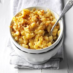 a bowl filled with macaroni and cheese on top of a white table cloth