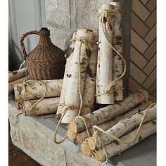 several logs are stacked on top of each other next to a basket and wicker basket