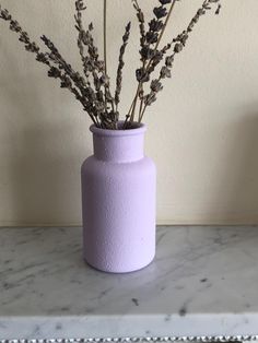 a purple vase sitting on top of a marble counter