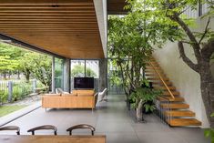 the inside of a house with stairs leading up to the second floor and trees in the living room