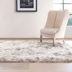 a chair sitting on top of a rug in a living room next to a window