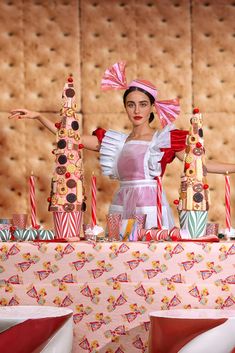 a woman dressed in costume standing behind a table with candy canes