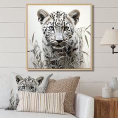 a white tiger in the wild looking at the camera while sitting on a couch with pillows