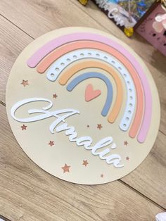 a sticker that says thank with a rainbow and stars in the background on a wooden table