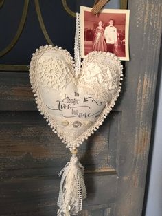 a white heart hanging from a door with an old photo on the front and back