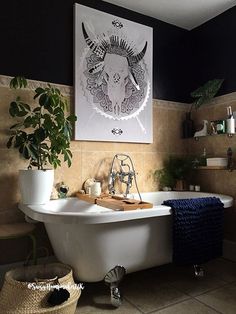 a bath tub sitting next to a bathroom sink under a painting on the wall above it