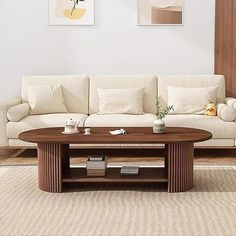 a living room with a white couch and wooden coffee table in front of the wall