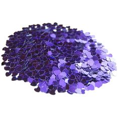 purple heart shaped confetti sitting on top of a white table