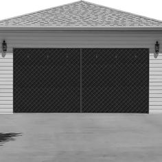 a black and white photo of a house with two garage doors on the side of it