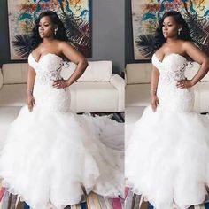 a woman in a white wedding dress standing next to a couch and posing for the camera