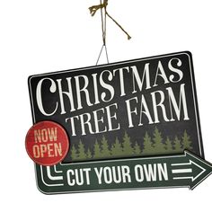 a christmas tree farm sign hanging off the side of a building with an arrow pointing to it