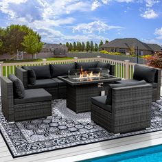 an outdoor fire pit surrounded by wicker furniture next to a swimming pool and fence