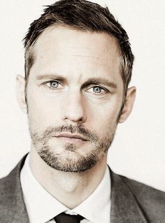 a black and white photo of a man in a suit looking at the camera with an intense look on his face