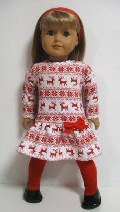 a doll wearing a red and white dress with deers on it's side