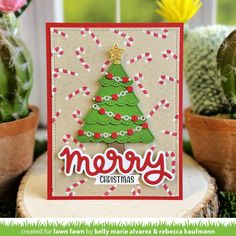 a card with a christmas tree on it and some cacti in the background