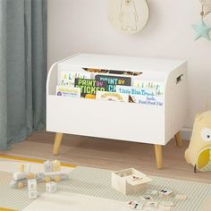 a white toy chest with books on it in a child's room