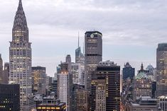 the city skyline is lit up at night, with skyscrapers in the foreground