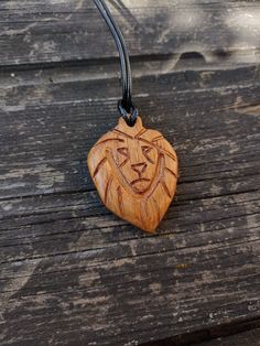 a wooden necklace with a carved lion head on it