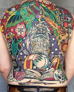 the back of a man's body with tattoos on it and an open book