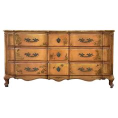 an old wooden dresser with many drawers and knobs on the front, painted in gold