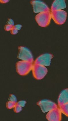 some pink and blue butterflies are flying in the dark sky with no one around them