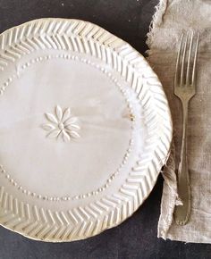 a white plate sitting on top of a table next to a fork and napkins