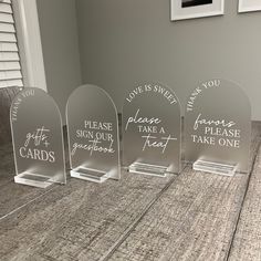 three clear acrylic signs with words on them sitting on a table in front of a window