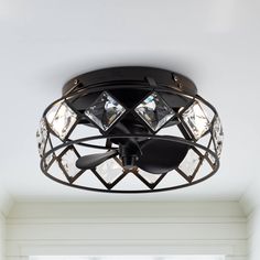 a black ceiling light with three lights on each side and an open window behind it