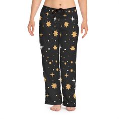 Enjoy a cozy night's sleep with these stylish star print pajama pants. Featuring a black background with gold and white stars, these lounge pants provide a comfortable fit for restful nights. Perfect for both relaxing at home and a good night's sleep, these pajama pants are sure to become your favorite nightwear. 100% polyester White seam thread Light fabric (6 oz/yd² (203 g/m Relaxed comfort fit Back elastic and black drawstring tie Sewn-in care label Assembled in the USA from globally sourced Black And Gold Lounge, Gold Lounge, Pj Bottoms, Sleep Shorts, White Stars, Pajama Robe, Print Pajamas, Care Label, Lounge Pants