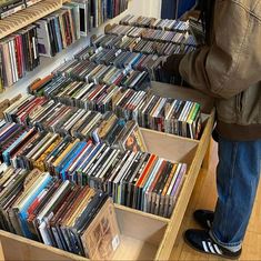 a person standing in front of a large amount of cds