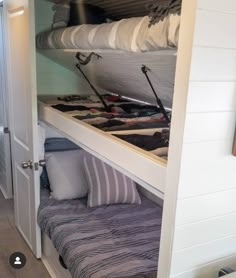 the bunk bed is built into the side of the wall and has two pull out beds