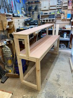 a workbench in a shop with tools and other woodworking supplies on the shelves