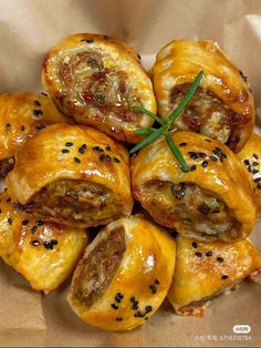 there are many pastries on the plate with some green garnish around them