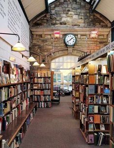 a library filled with lots of books under a clock