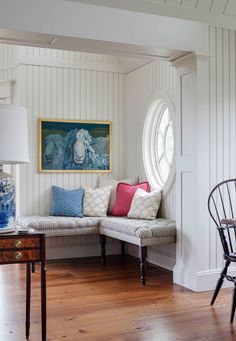 a living room filled with furniture and a painting on the wall above it's windows